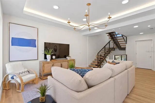 a living room with furniture a mirror and wooden floor