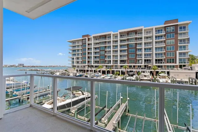 a kitchen with stainless steel appliances granite countertop a stove top oven a refrigerator a sink and white cabinets with wooden floor