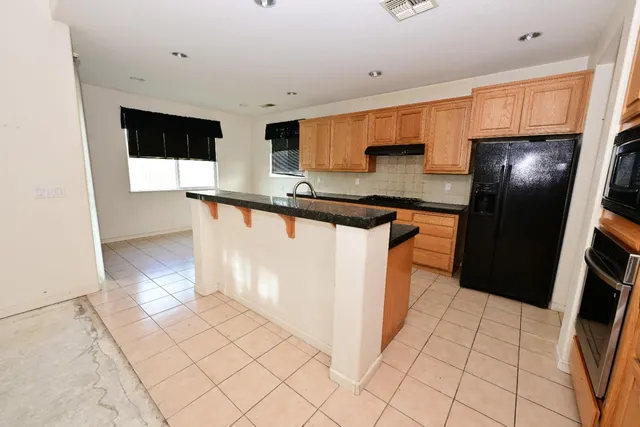 a kitchen with stainless steel appliances a refrigerator a sink a stove a microwave a counter top and cabinets