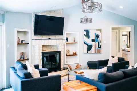 a living room with furniture a flat screen tv and a fireplace