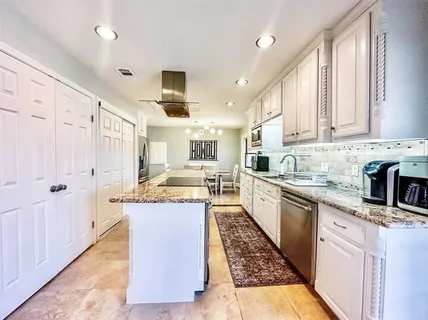 a large kitchen with stainless steel appliances granite countertop a stove a sink dishwasher and a refrigerator