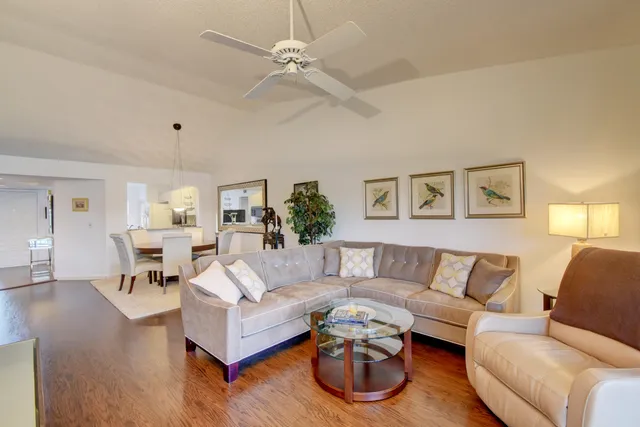 a dining room with furniture a chandelier and wooden floor