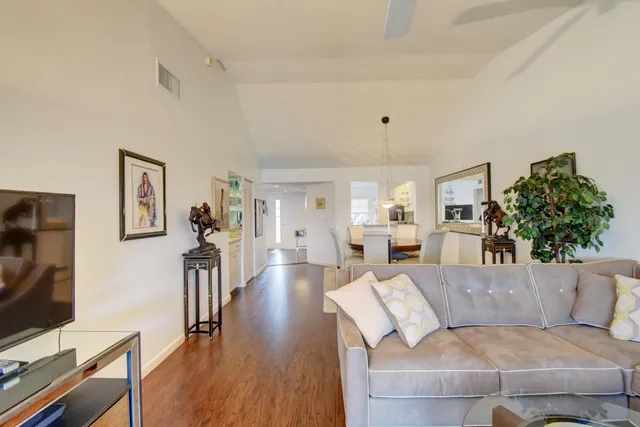 a dining room with furniture a chandelier and wooden floor