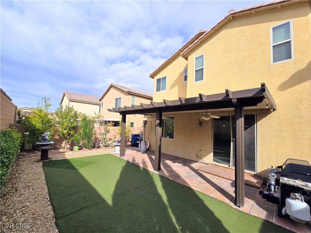10855 Casco Bay Street Las Vegas, NV 89179 - Photo 47 of 64 Rear view of house with ceiling fan, a fenced backyard, stucco siding, and a pergola