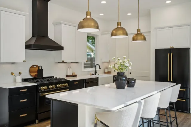 a kitchen with stainless steel appliances a stove a sink a refrigerator and cabinets