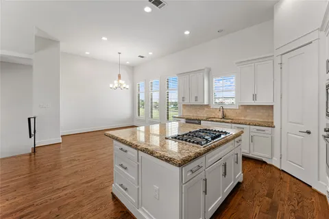 a kitchen with granite countertop a sink stove and cabinets