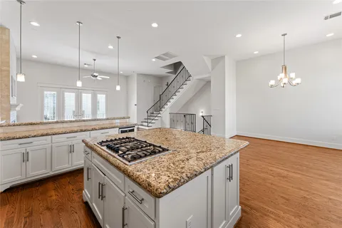 a kitchen with stainless steel appliances granite countertop a sink stove and wooden floor