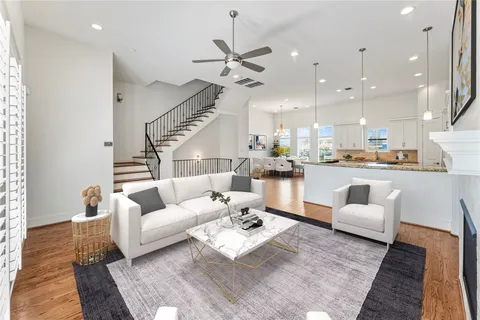 a living room with furniture kitchen view and a chandelier