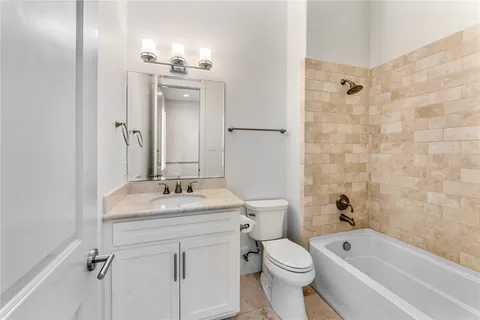 a bathroom with a granite countertop sink a toilet and shower