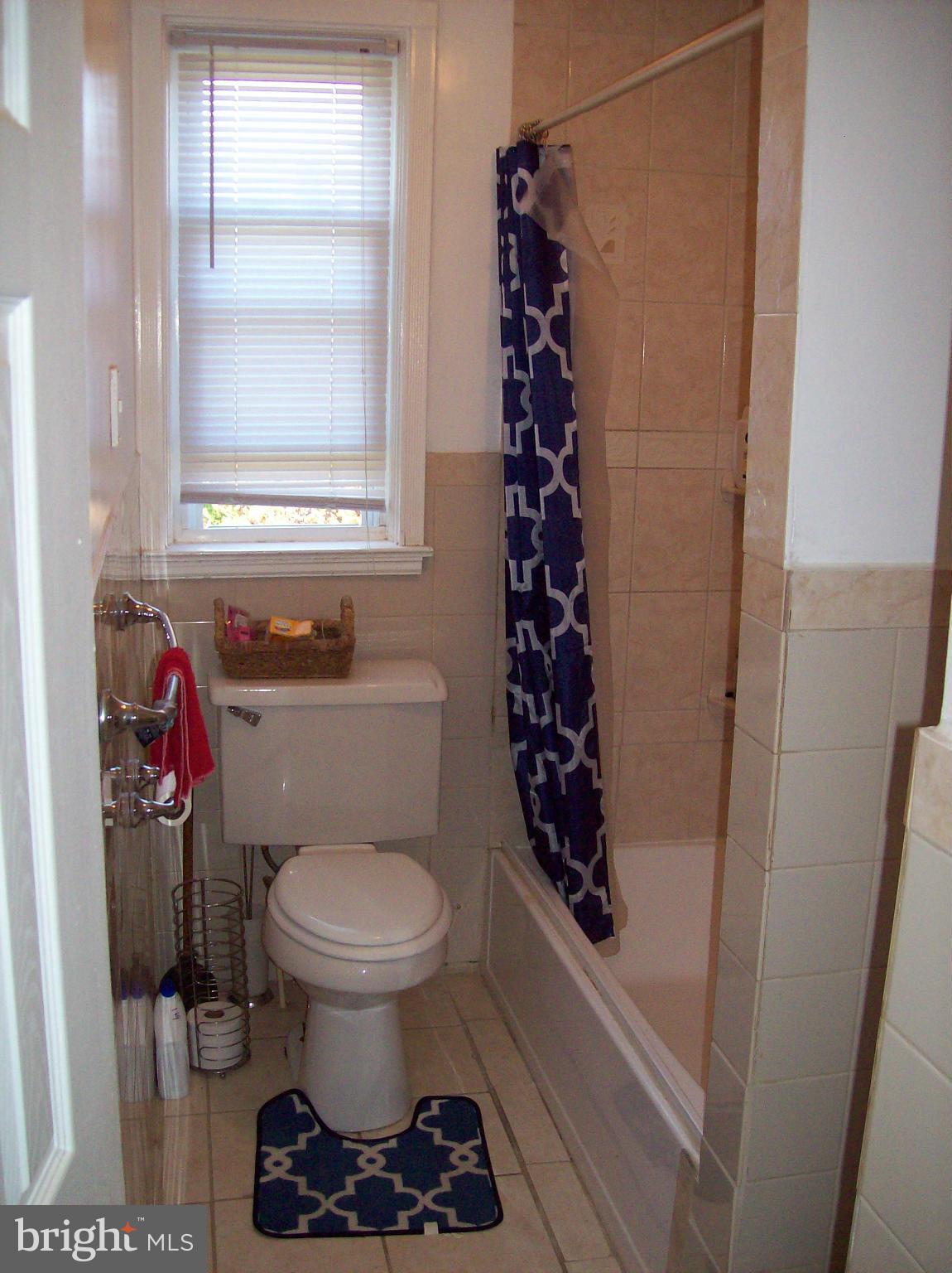 1534 Northwick Road Baltimore, MD 21218 - Photo 11 of 12 a bathroom with a toilet and a shower curtain