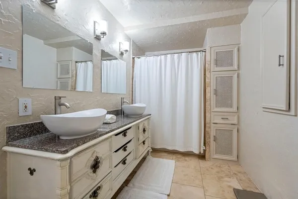 a spacious bathroom with a granite countertop sink and a mirror