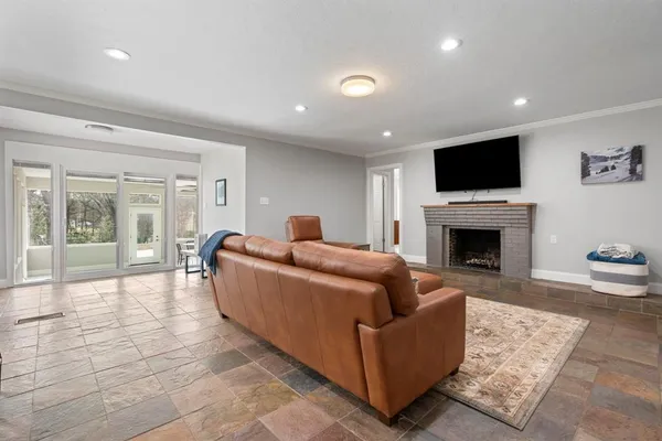 a living room with furniture a flat screen tv and a fireplace