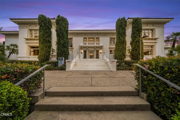 a dining room with furniture a chandelier and wooden floor