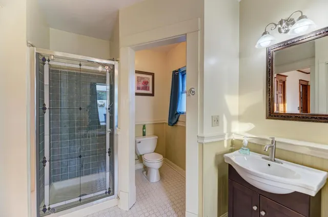 a bathroom with a sink a toilet and shower