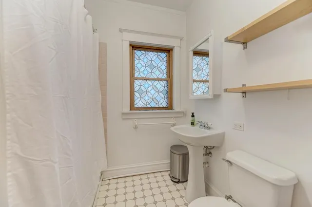 a bathroom with a sink toilet and a window