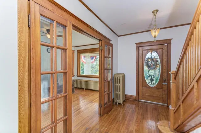 a view of a hallway with wooden floor and a window