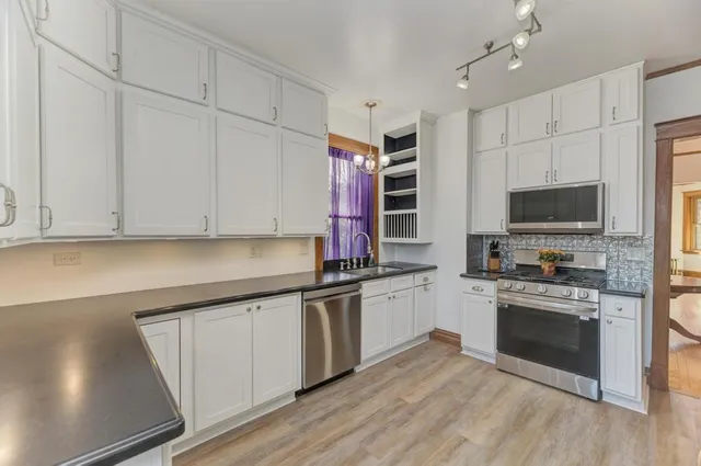 a kitchen with stainless steel appliances granite countertop a stove and a sink