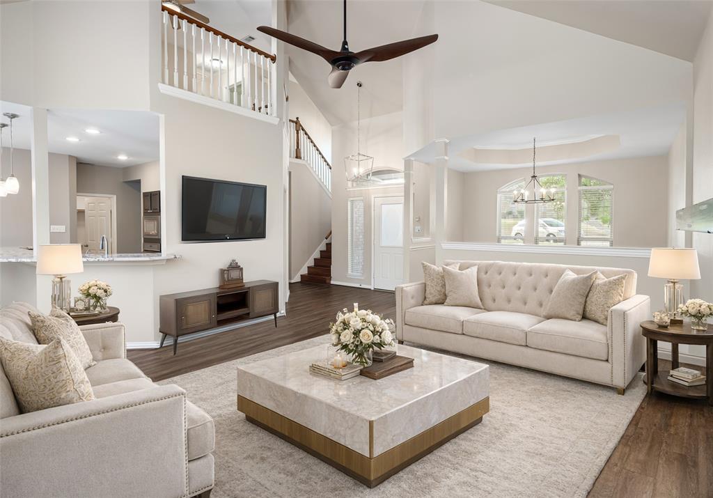 a living room with furniture a flat screen tv and a chandelier