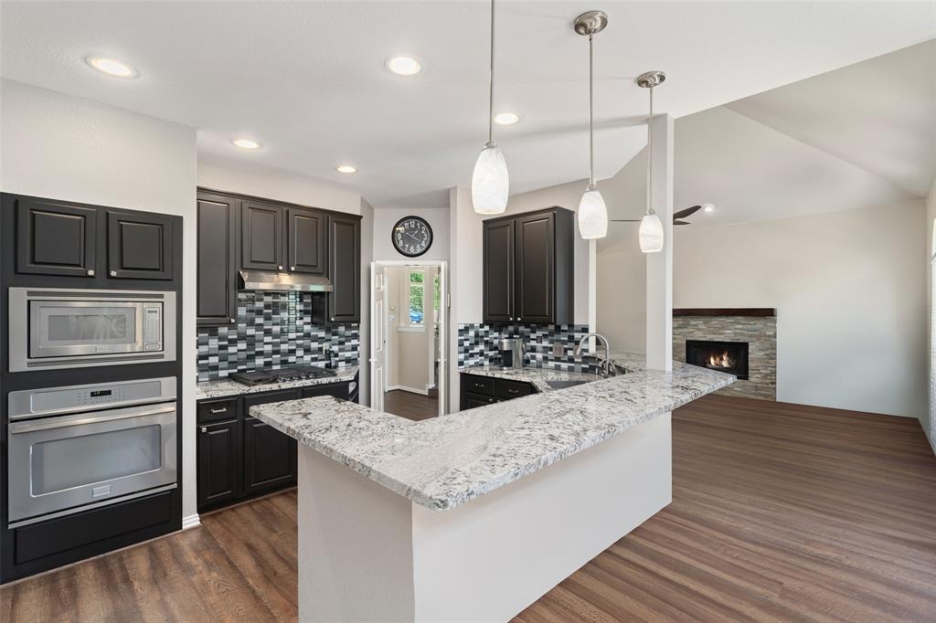 103 Sierra Court Allen, TX 75013 - Photo 5 of 28 a kitchen with stainless steel appliances kitchen island granite countertop a stove a refrigerator and a wooden cabinets
