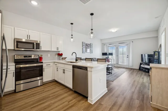 a kitchen with stainless steel appliances kitchen island granite countertop a stove a sink and a refrigerator