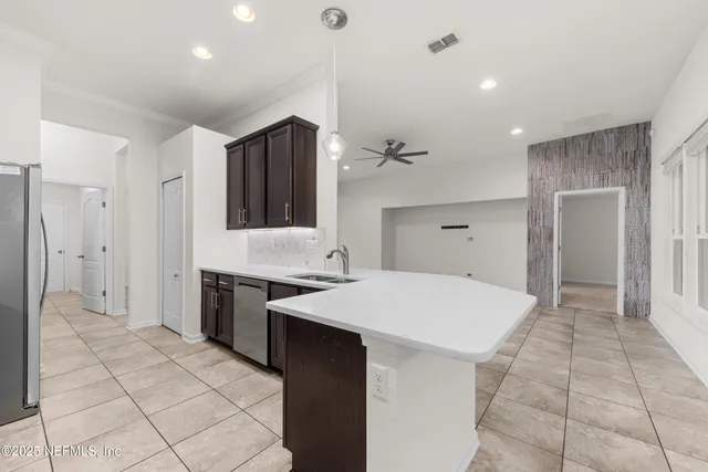a large white kitchen with a stove a refrigerator a sink and dishwasher