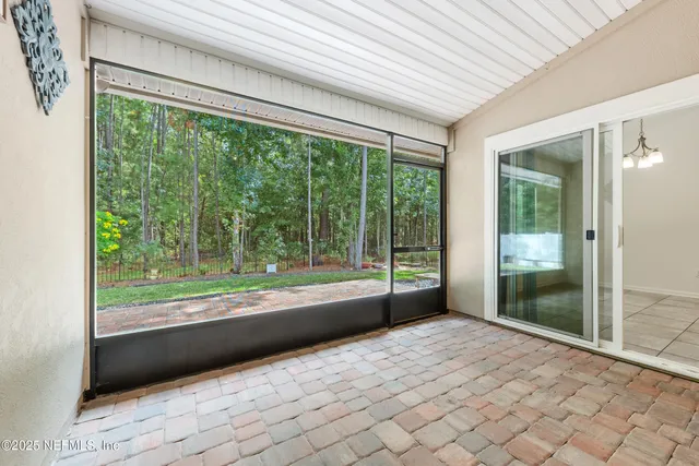 a view of an empty room with window and bathroom