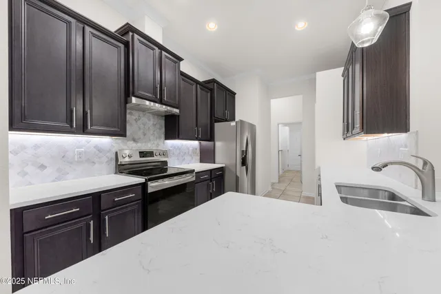 a kitchen with stainless steel appliances granite countertop a sink refrigerator and cabinets
