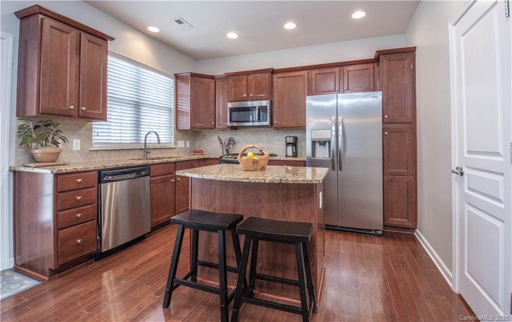 903 Lyndley Drive Fort Mill, SC 29708 - Photo 11 of 47 a kitchen with a table chairs refrigerator microwave and cabinets