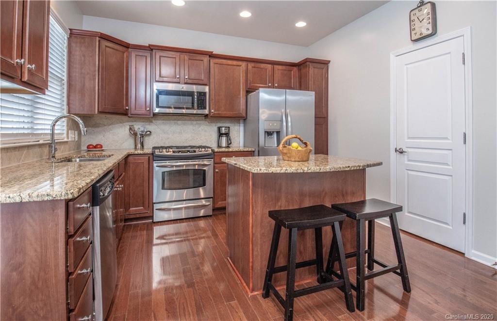 903 Lyndley Drive Fort Mill, SC 29708 - Photo 12 of 47 a kitchen with stainless steel appliances granite countertop a stove top oven a refrigerator a sink and a stove with wooden floor