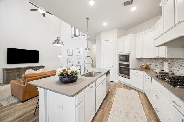 a kitchen with stainless steel appliances a sink stove and cabinets