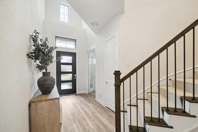 a view of a hallway with wooden floor and stairs