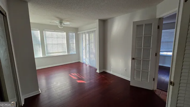 an empty room with wooden floor and windows