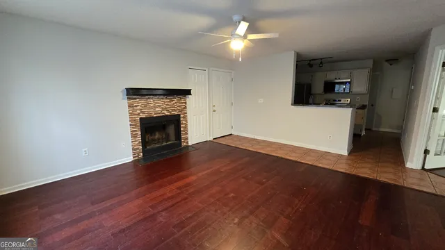 an empty room with wooden floor fireplace and a window