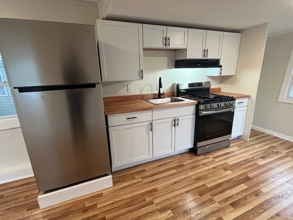 229 Miller Street, Unit C1 Ludlow, MA 01056 - Photo 4 of 19 a kitchen with stainless steel appliances and wooden cabinets