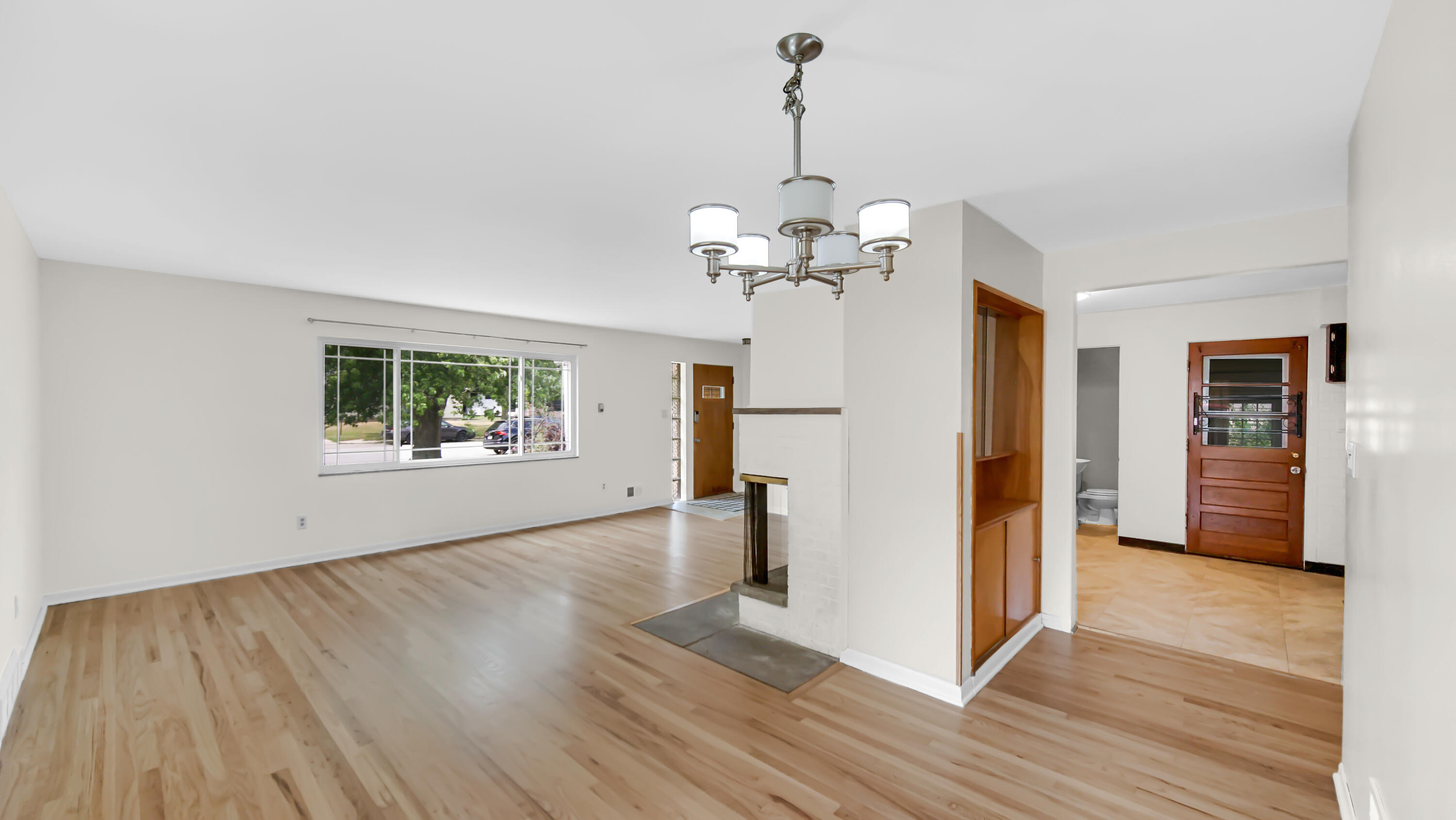 6957 Ash Avenue Gary, IN 46403 - Photo 6 of 22 a view of a room with wooden floor staircase and a kitchen