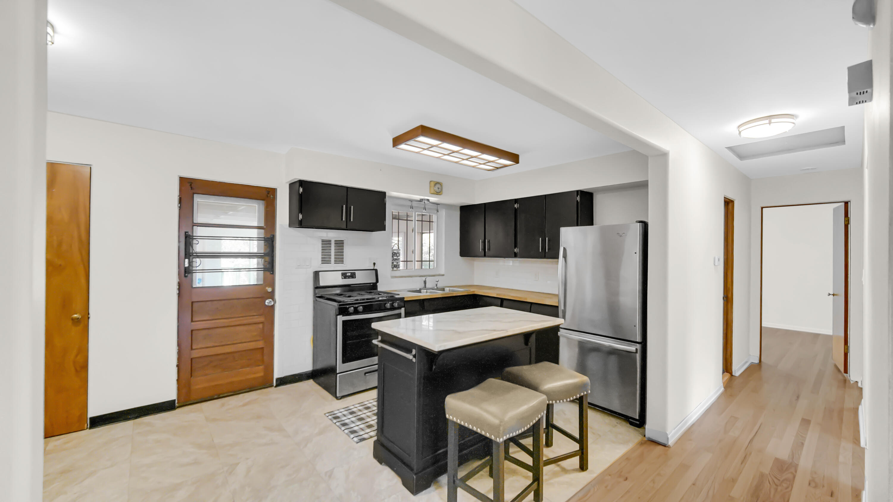 6957 Ash Avenue Gary, IN 46403 - Photo 7 of 22 a kitchen with stainless steel appliances granite countertop a refrigerator stove and microwave