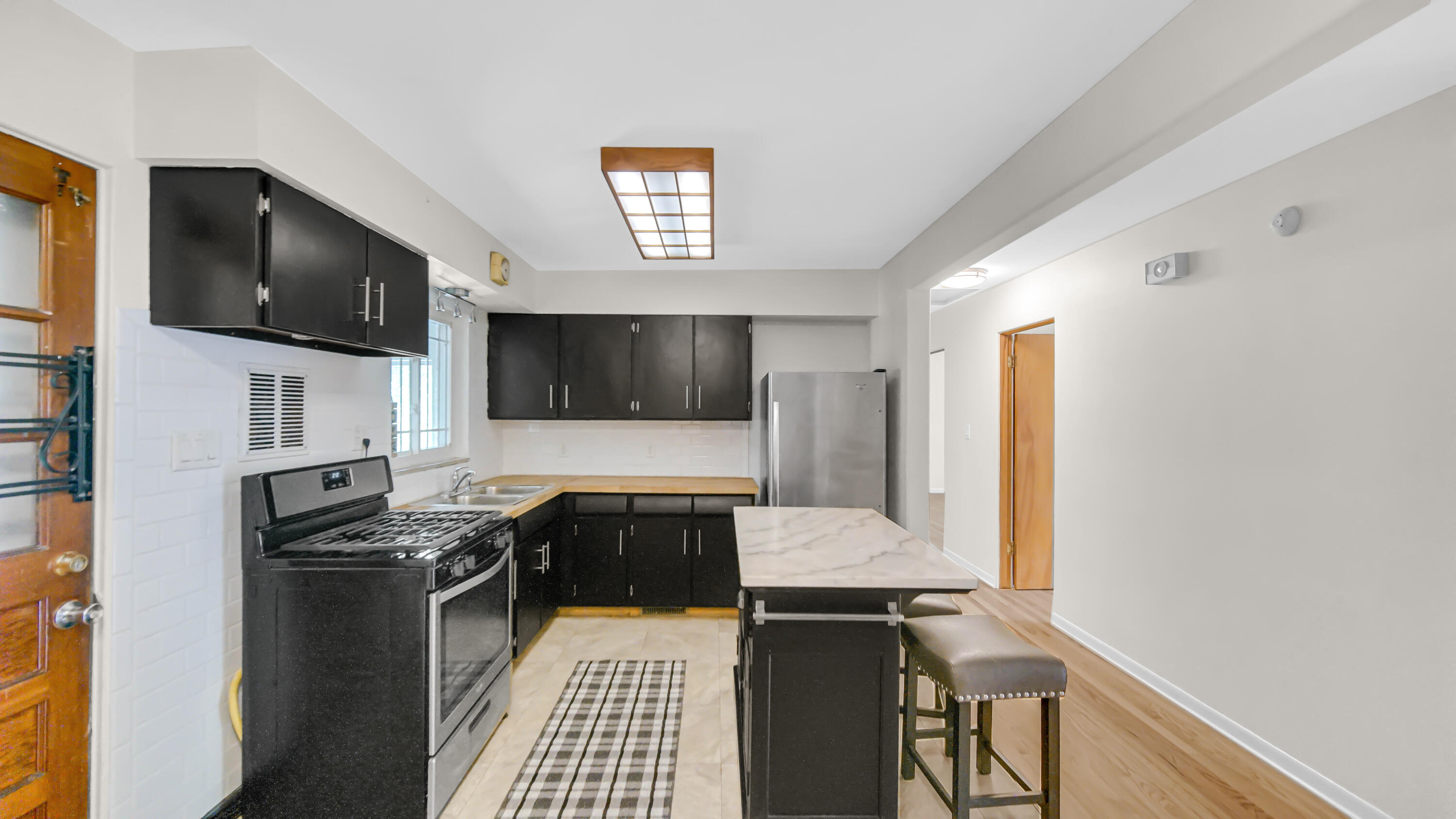 6957 Ash Avenue Gary, IN 46403 - Photo 9 of 22 a living room with stainless steel appliances kitchen island granite countertop a stove and a microwave