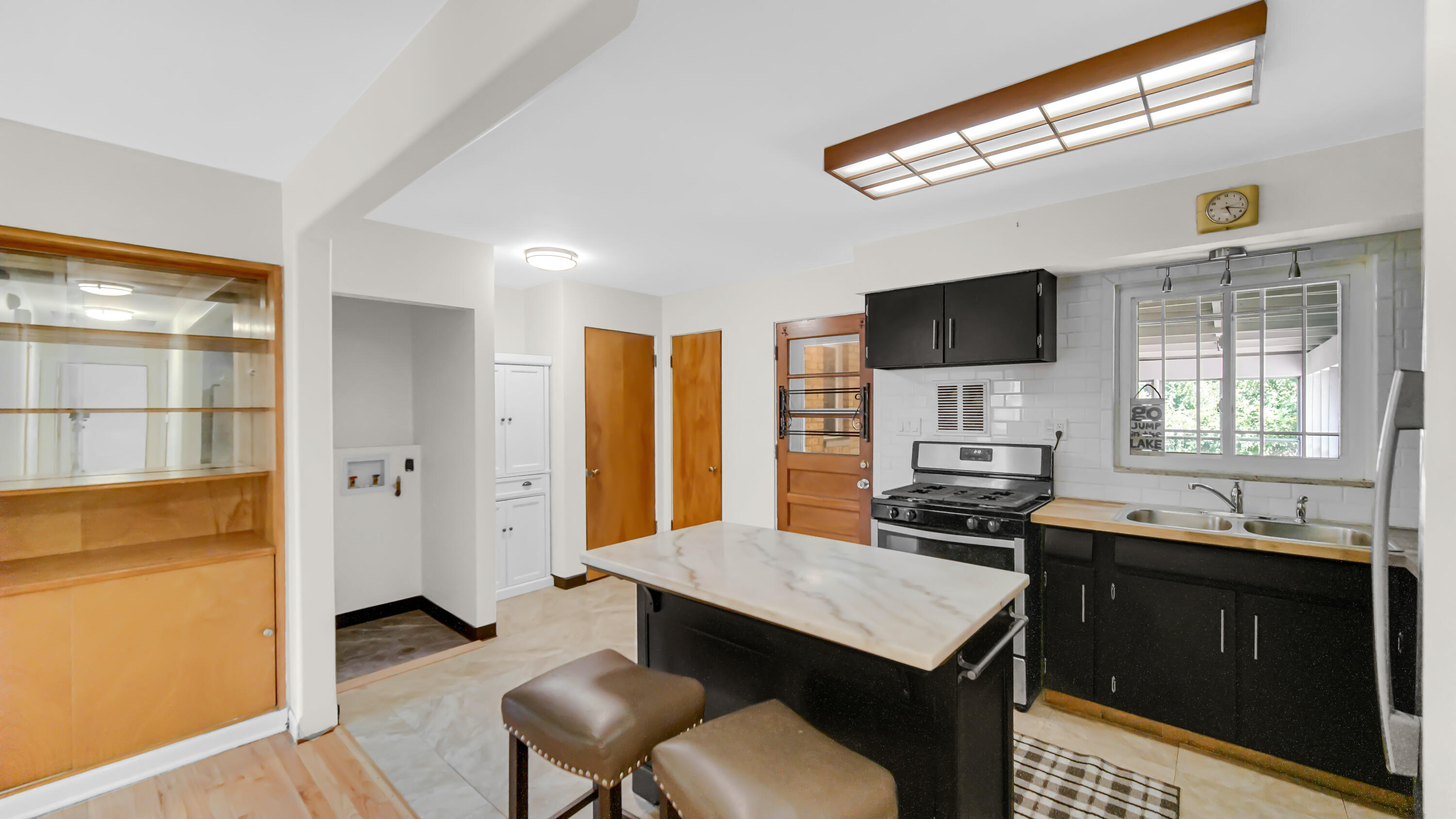 6957 Ash Avenue Gary, IN 46403 - Photo 10 of 22 a kitchen with a stove a sink dishwasher a refrigerator with a dining table and chair with wooden floor