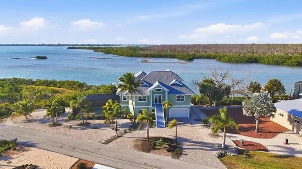 an aerial view of a house with a garden and lake view