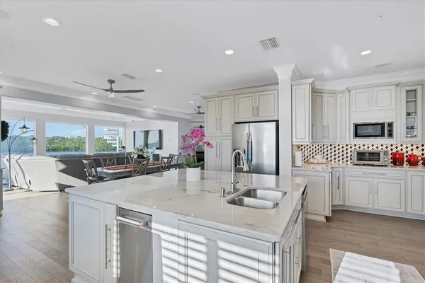 a kitchen with stainless steel appliances granite countertop a stove top oven a sink dishwasher and a refrigerator