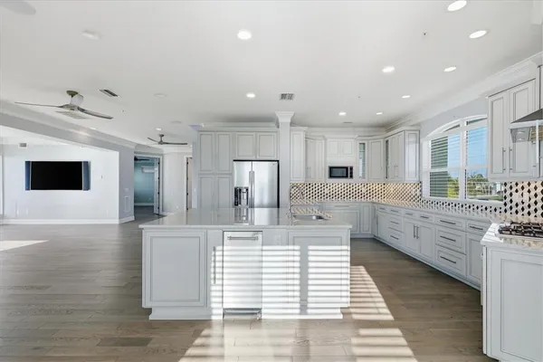 a kitchen with white cabinets and appliances
