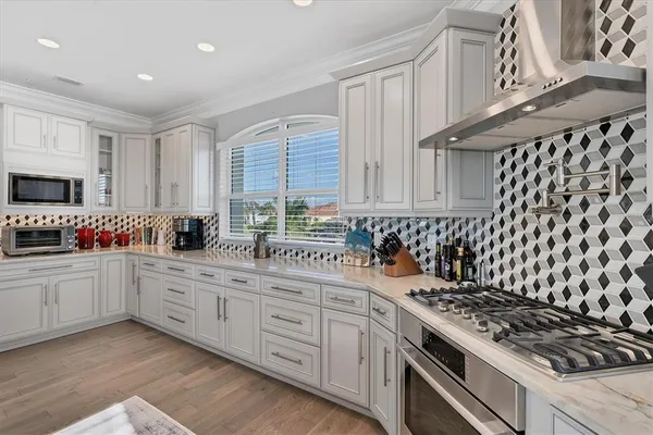 a kitchen with white cabinets and stainless steel appliances