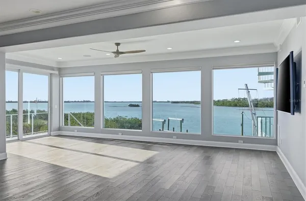 a living room with wooden floor and a floor to ceiling window