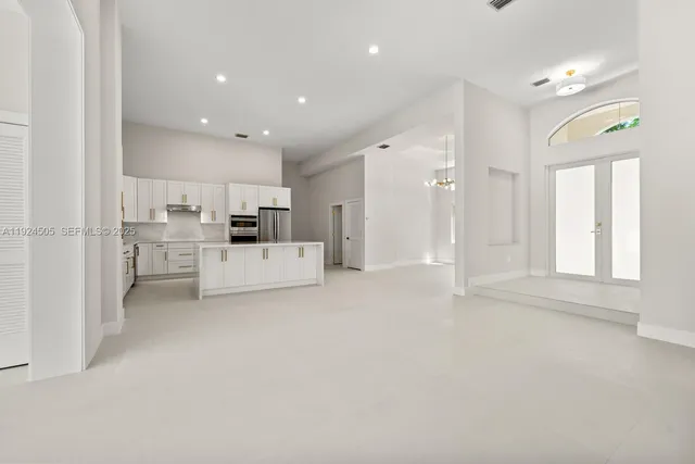 a view of a kitchen with white cabinets and stainless steel appliances