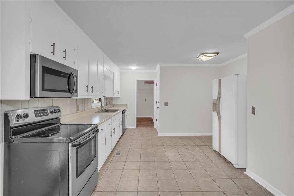 32 Cox Road Southeast Cartersville, GA 30121 - Photo 11 of 60 a large white kitchen with stainless steel appliances granite countertop a stove a sink and a microwave