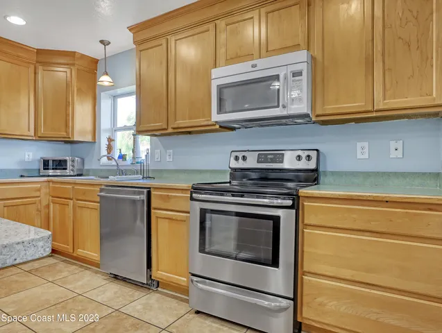 a kitchen with stainless steel appliances granite countertop a stove microwave and cabinets