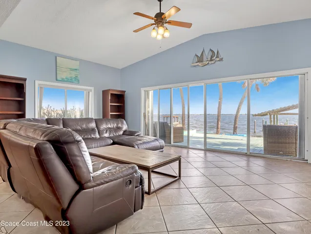 a living room with furniture and a floor to ceiling window