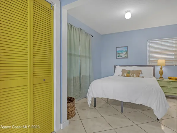 a bedroom with a bed and a potted plant