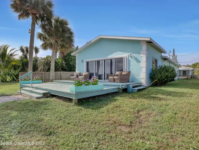 a view of a house with backyard and sitting area