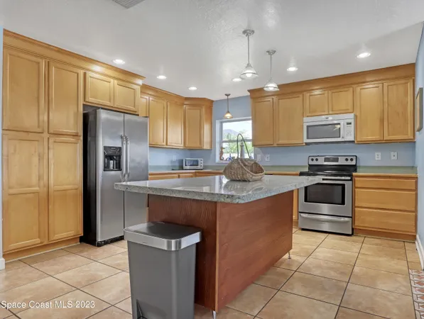 a kitchen with stainless steel appliances granite countertop a stove a sink and a refrigerator